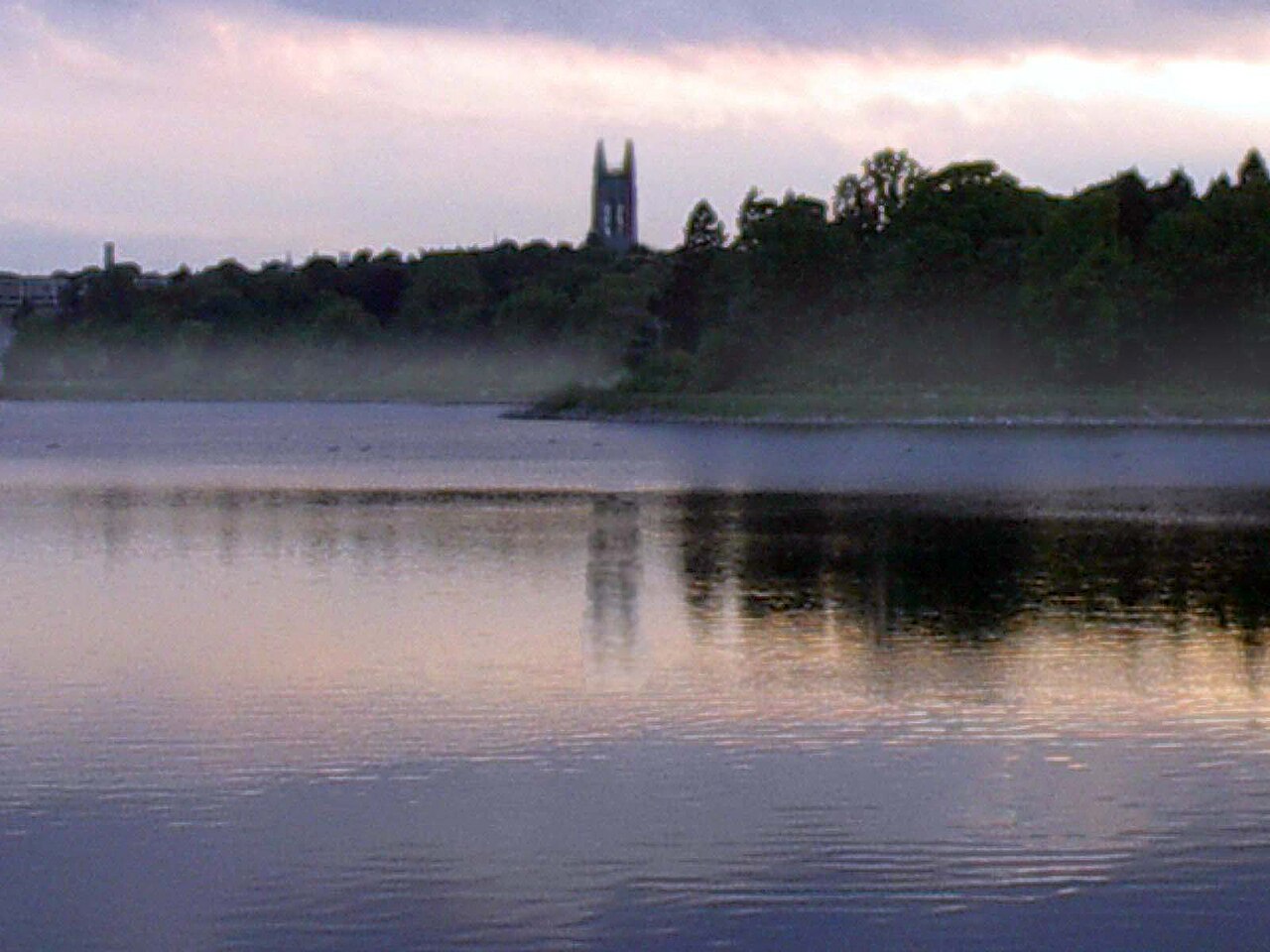 Башня Гассон-холла Boston College отражается в воде